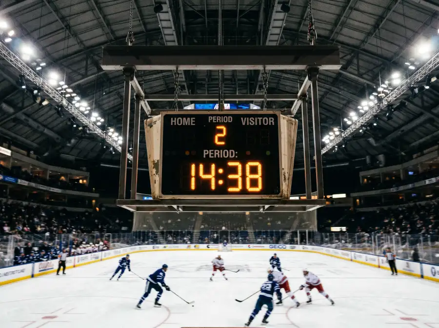 Reloj de partido de hockey sobre hielo visible sobre la pista con jugadores al fondo